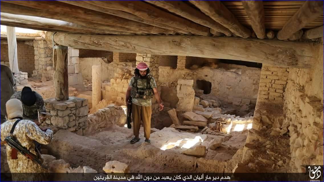 An ISIS fighter stands in the rubble of St. Elian monastery, an Assyrian monastery from the 5th century, after it has been destroyed.